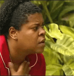 a woman in a red shirt is holding her chest