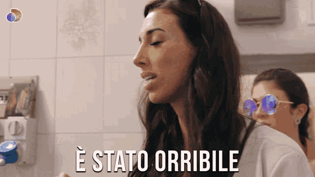 a woman wearing sunglasses says " e stato orribile " next to another woman