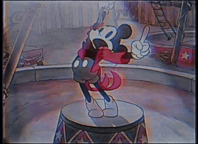 a cartoon of mickey mouse standing on a drum with his mouth open