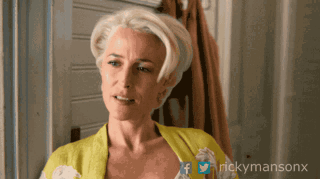 a woman in a yellow robe with rickymansonx on the bottom right