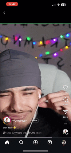 a phone screen shows a video of a man wearing headphones