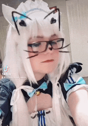 a girl wearing glasses and a cat costume has a tiktok icon on her face