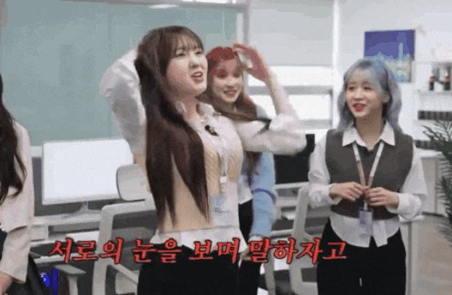 a group of girls are standing in a room with korean writing on the bottom