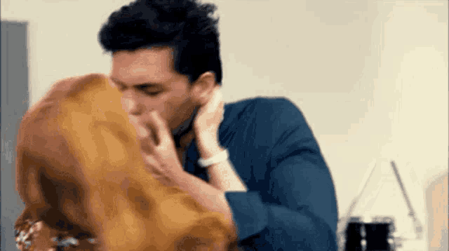 a man is kissing a woman on the forehead