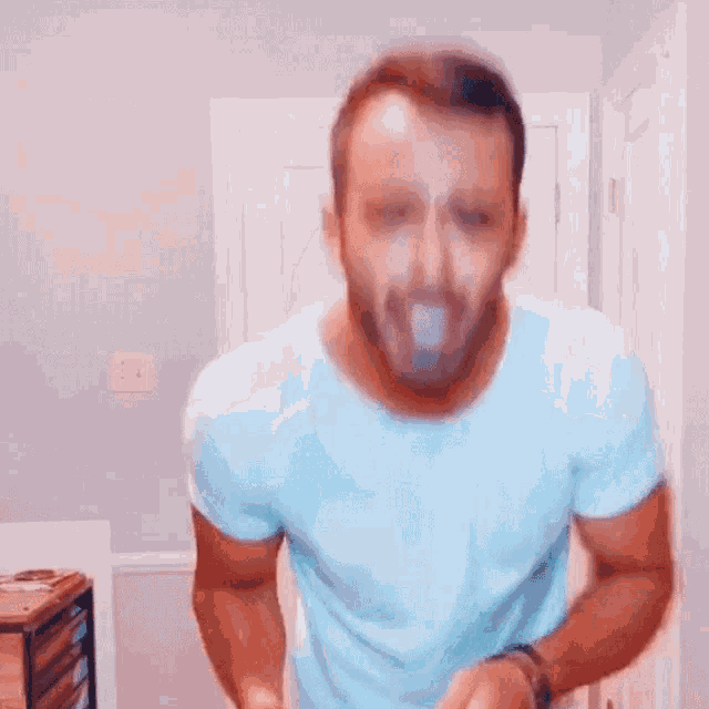 a man in a blue shirt is standing in a room .