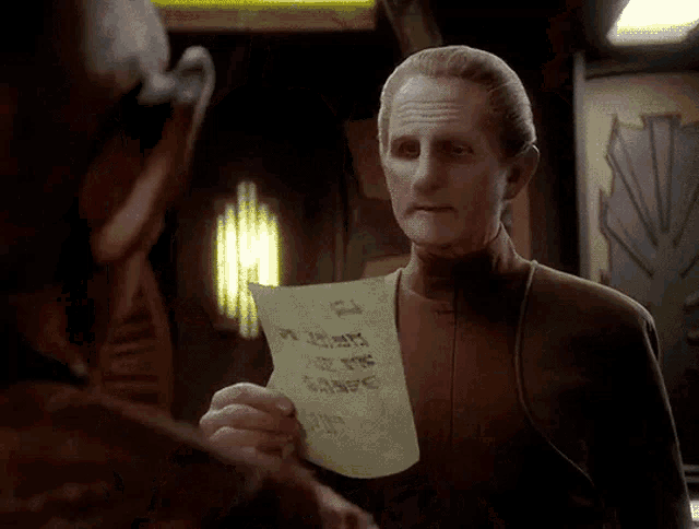 a man holding a piece of paper that says ' i love you ' on it