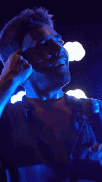 a man is singing into a microphone with his shirt off