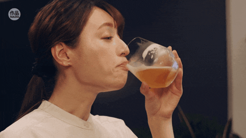 a woman drinking from a glass with a sticker that says ' samurai '