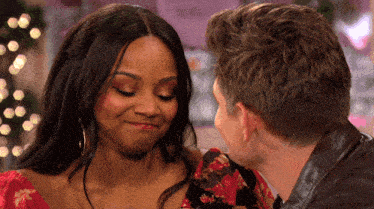 a man and a woman are looking at each other and smiling