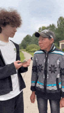 a man wearing a hat with the letter r on it is talking to a young man