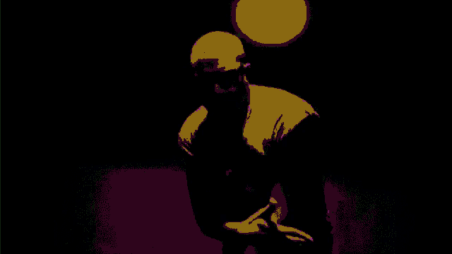 a man wearing sunglasses and a yellow shirt is standing in a dark room .