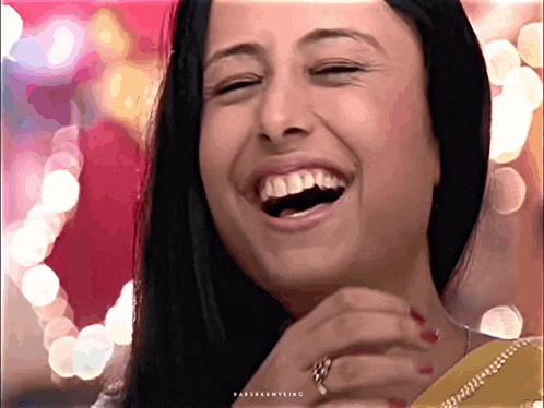 a close up of a woman 's face with the word laughing on the bottom left