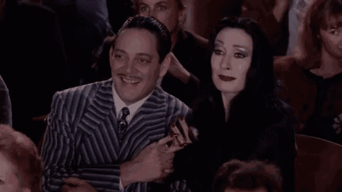 a man and a woman are sitting next to each other in a crowd .
