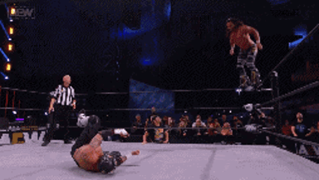 two men are wrestling in a ring with a referee and the word reign on the bottom