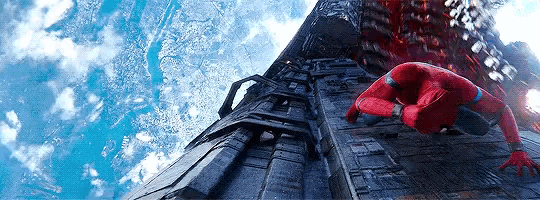 a man in a spiderman suit is crawling up a ladder .