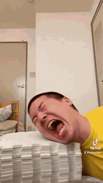 a man laying on a pile of dominoes with his mouth open