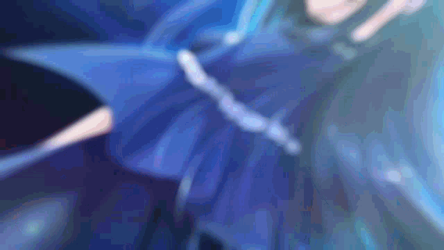 a blurry picture of a person in a blue dress with a chain around their waist