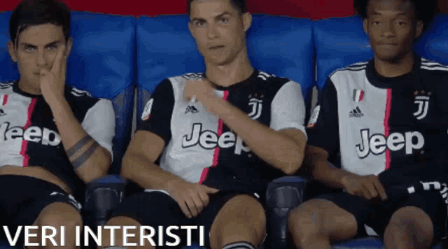 three soccer players wearing jeep jerseys are sitting on a bench