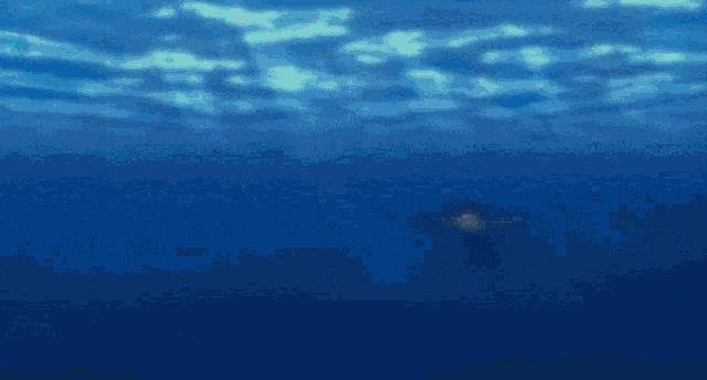a man is riding on the back of a large fish in the ocean .