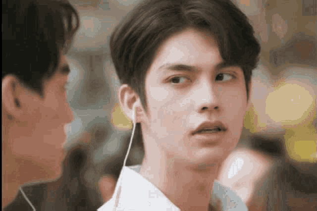 a close up of a young man wearing ear buds .