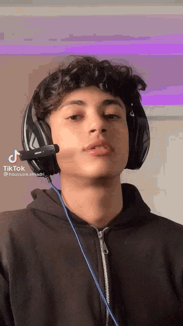 a young man wearing headphones with a microphone attached to his head