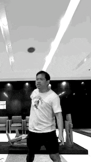 a man is kneeling down in a black and white photo in a room .