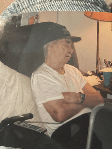 a man wearing a hat that says ' texas ' on it sits in a chair with his arms crossed