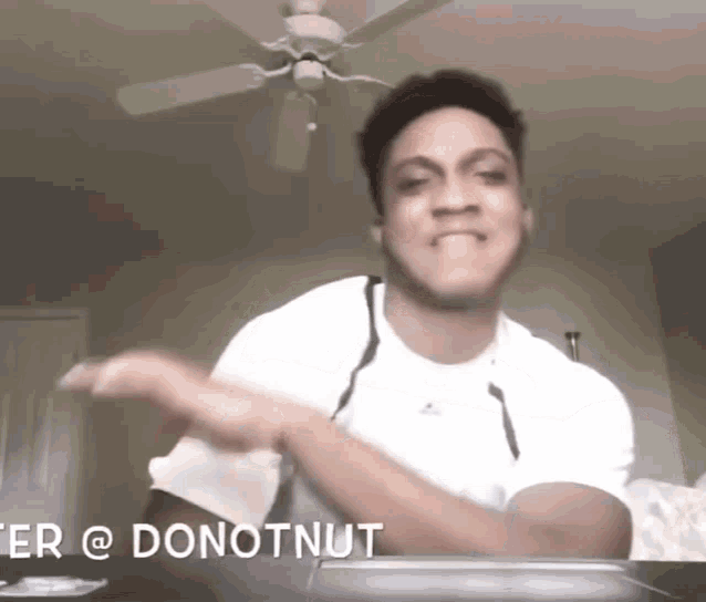 a man in a white shirt is standing in front of a laptop with the words " donotnut " on the bottom