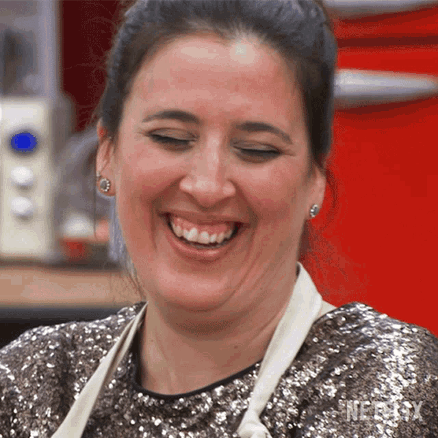 a woman wearing a sequined top is smiling with netflix written on the bottom