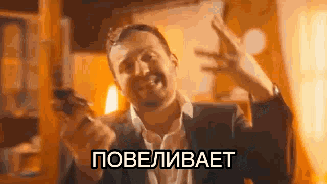 a man in a suit is holding a cell phone and making a peace sign in russian .