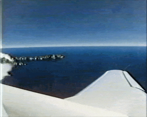 a plane is flying over a body of water with mountains in the distance