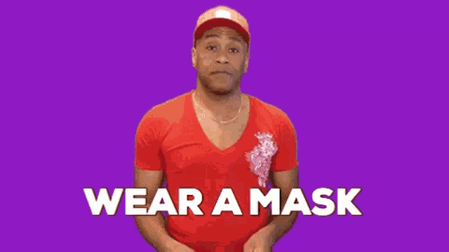 a man wearing a red shirt and a hat says wear a mask on a purple background .