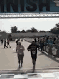 a blurry picture of people running in a race with the word finish in the background .