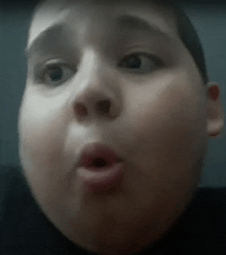 a close up of a person 's face with a surprised look on their face .