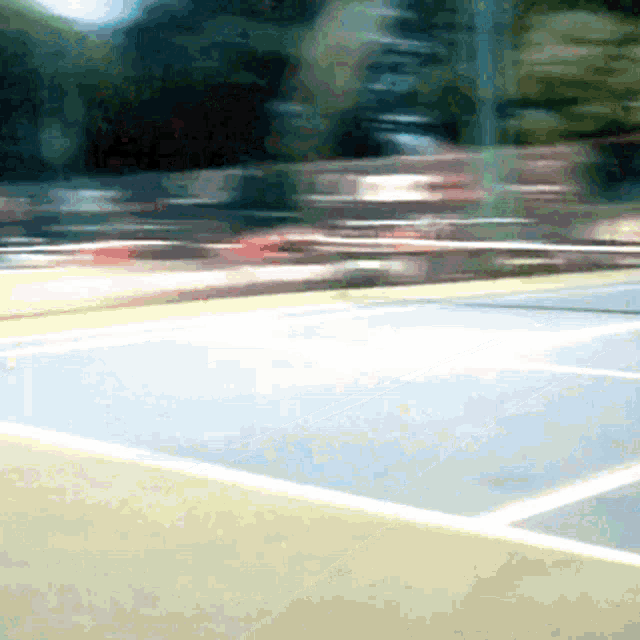 a blurry picture of a tennis court with a blurred background