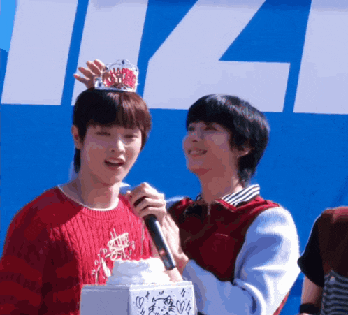 a boy wearing a crown on his head holds a microphone