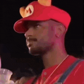 a man is wearing a red hat with ears on it and a mushroom on it .