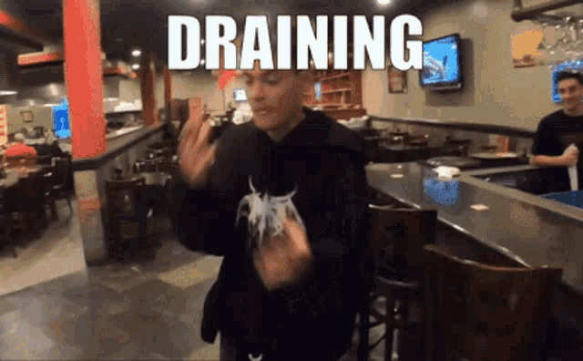 a man dancing in a restaurant with the word draining written above him