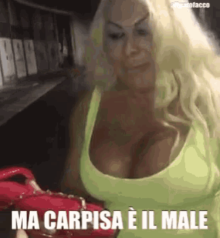 a woman with very large breasts is wearing a green tank top that says ma carpisa e il male on it