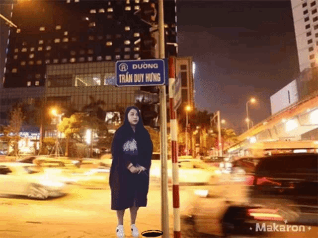 a woman stands under a street sign that says dương
