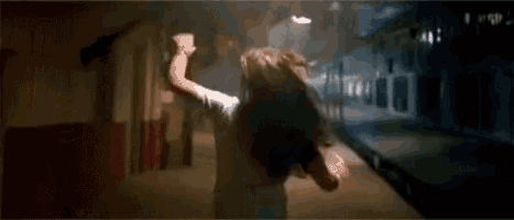 a woman is crawling on the ground in a dark room .