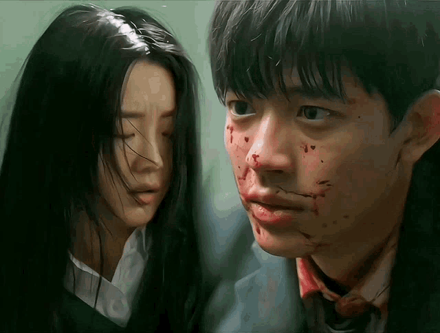 a man with blood on his face is looking at a woman