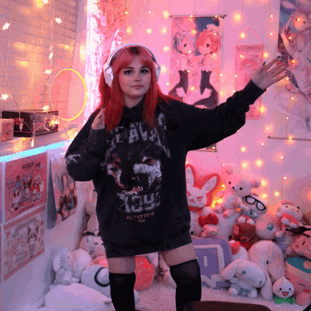 a girl with red hair wearing headphones and a black hoodie that says ' heaven ' on it