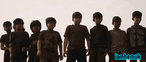 a group of boys salute in front of a sign that says iamhemuk