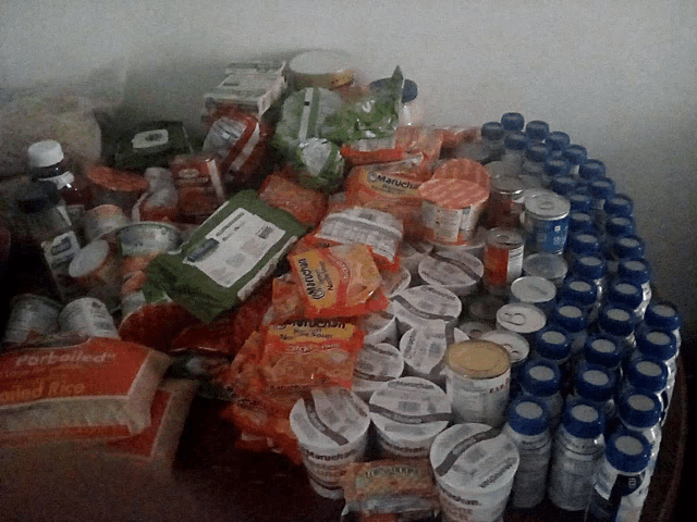 a bunch of food items including a bag of herbelled rice on a table