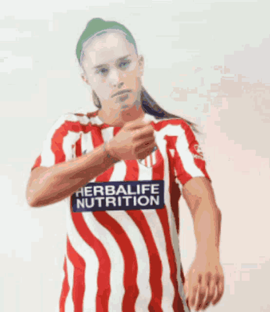 a woman wearing a red and white striped shirt with the word herbalife nutrition on it
