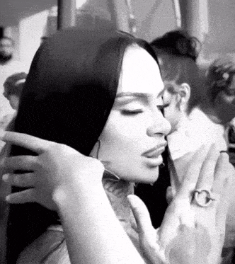 a black and white photo of a woman with a tattoo on her face .
