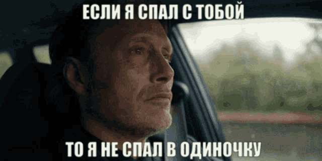 a man is sitting in a car with a caption in russian
