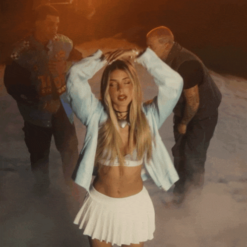 a woman in a white pleated skirt is surrounded by men