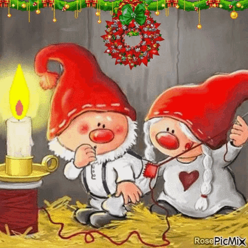 a couple of gnomes sitting next to a candle and a wreath